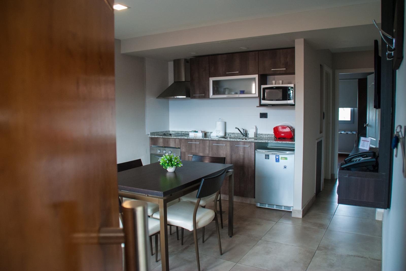 Vista del departamento desde la entrada: cocina, comedor y living