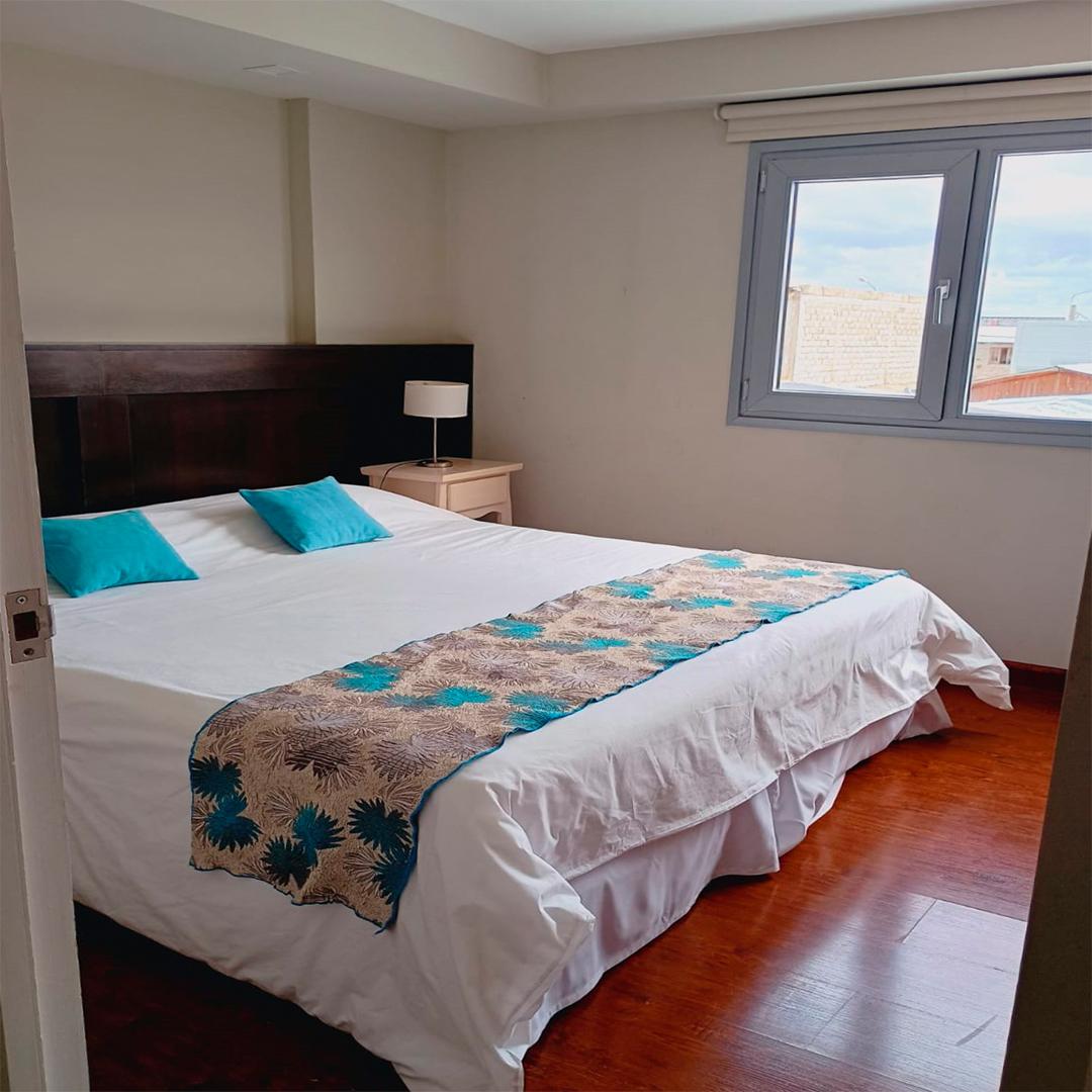 Dormitorio con cama doble junto a la ventana