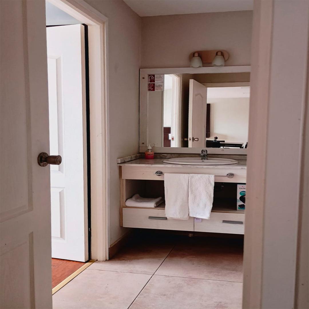 Antesala del baño con vanitory, espejo y toallas